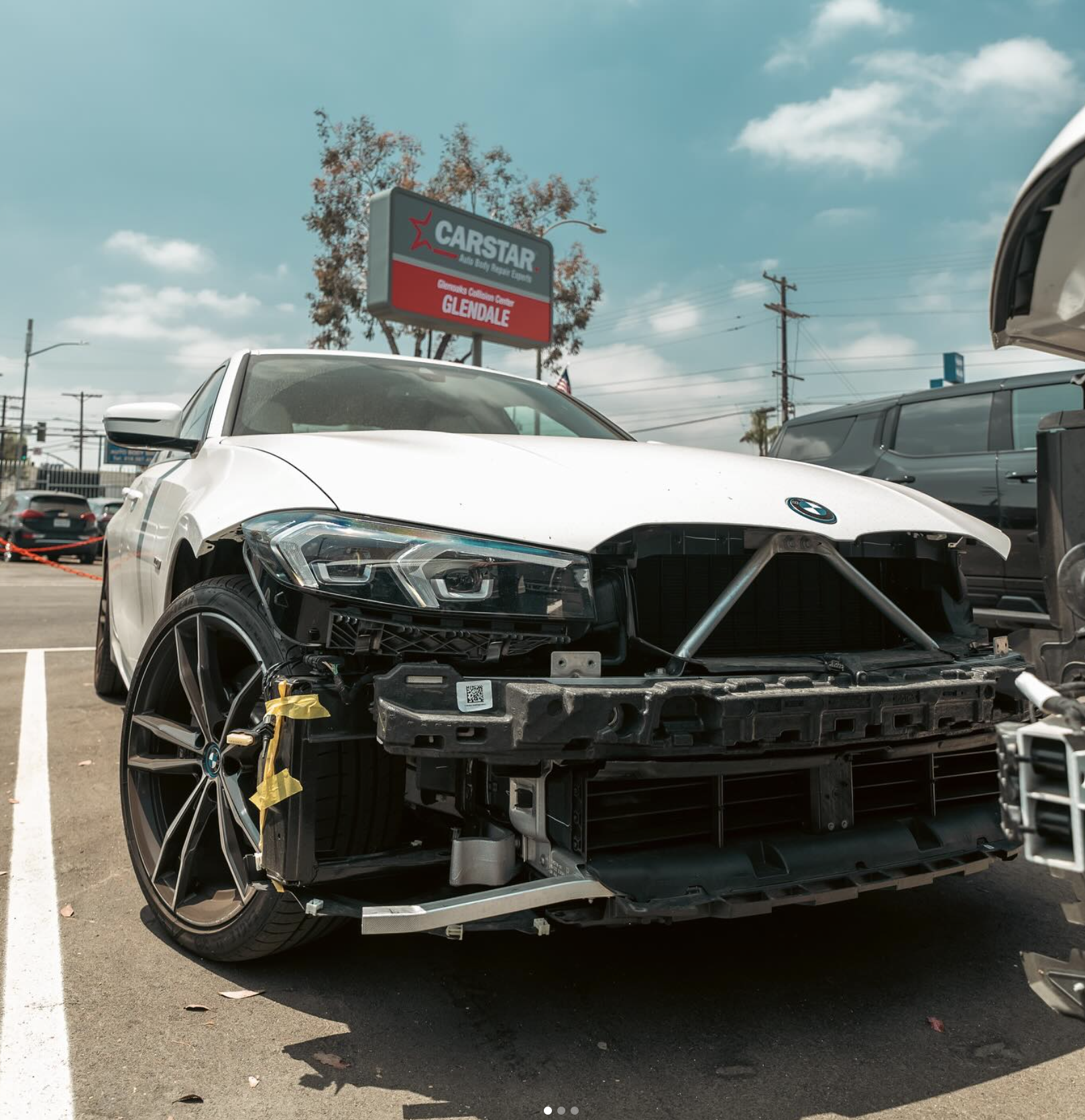 White BMW with its front bumper removed for collision repair at CARSTAR Glendale