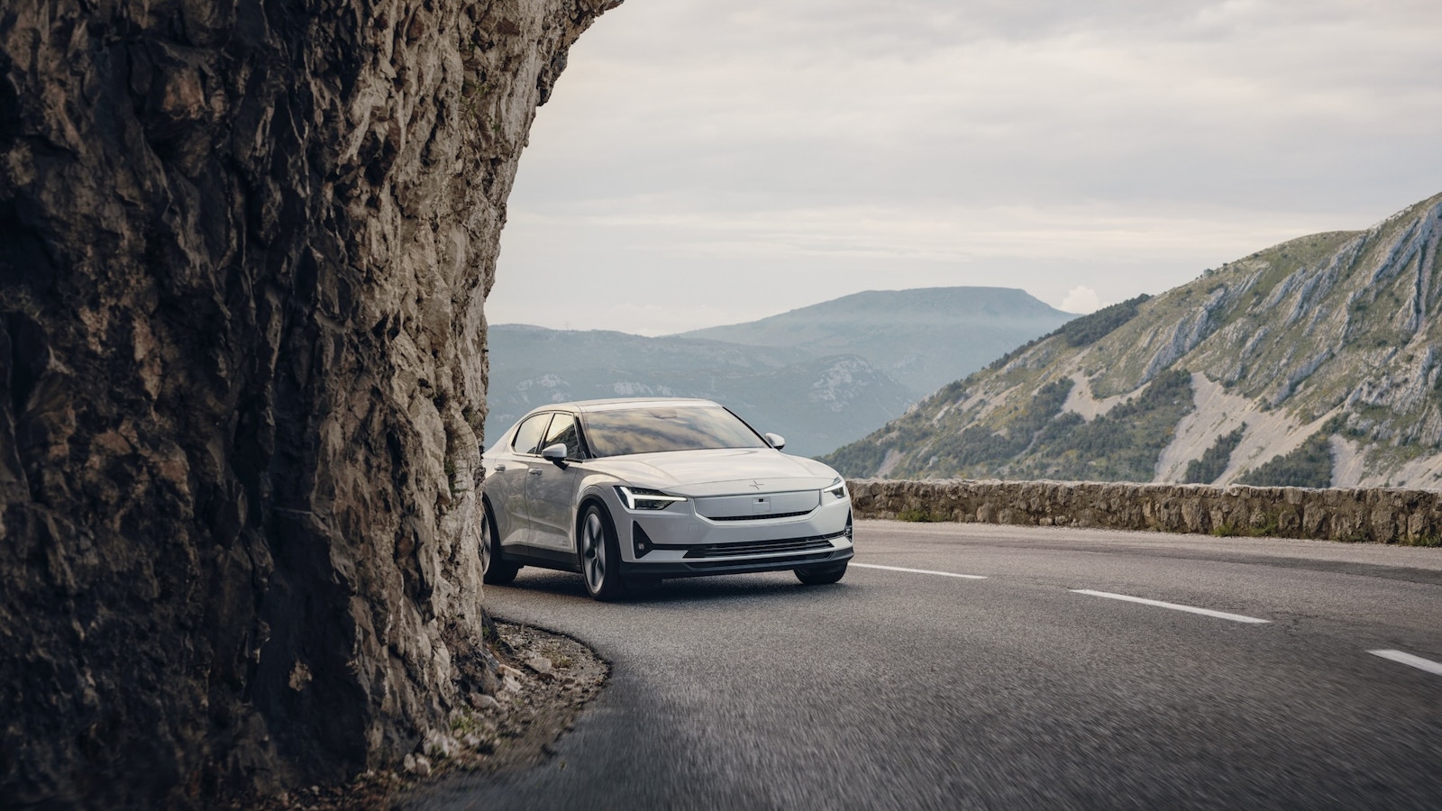 White Polestar 2 electric vehicle driving on a mountain road